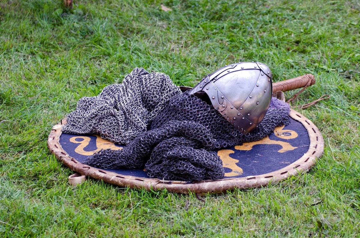 Medieval chainmail and helmet placed on a shield on the grass at the Arkansas Renaissance Festival.
