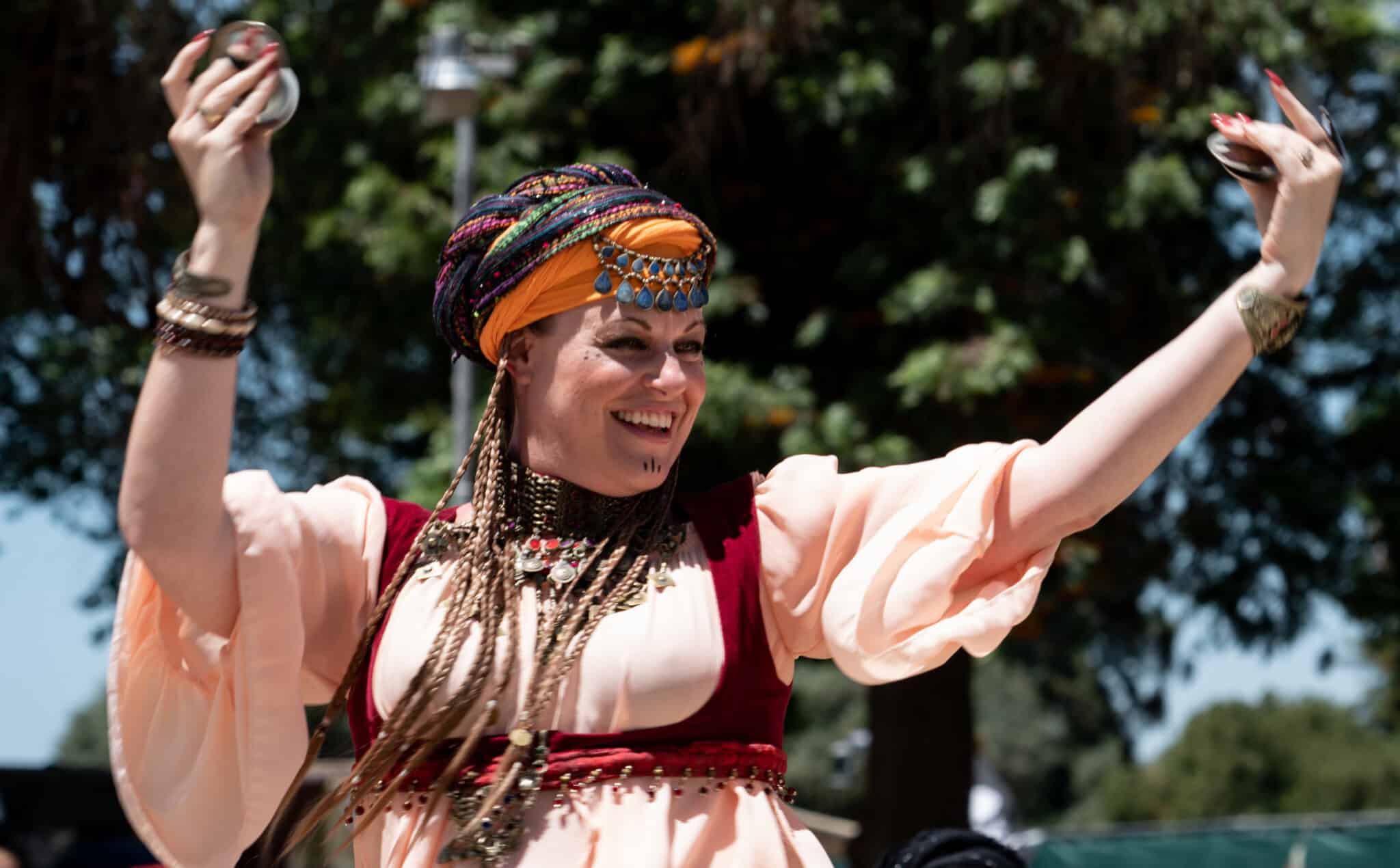 A belly dancer dances with finger cymbals at the Arkansas Renaissance Festival.